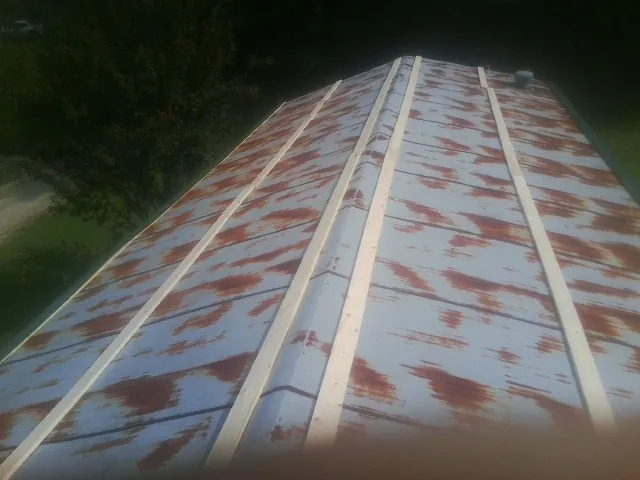Rusted metal roof panels with new wood purlins before replacement — Storm Damage Roof Repair in New Hartford by Roofing Brothers