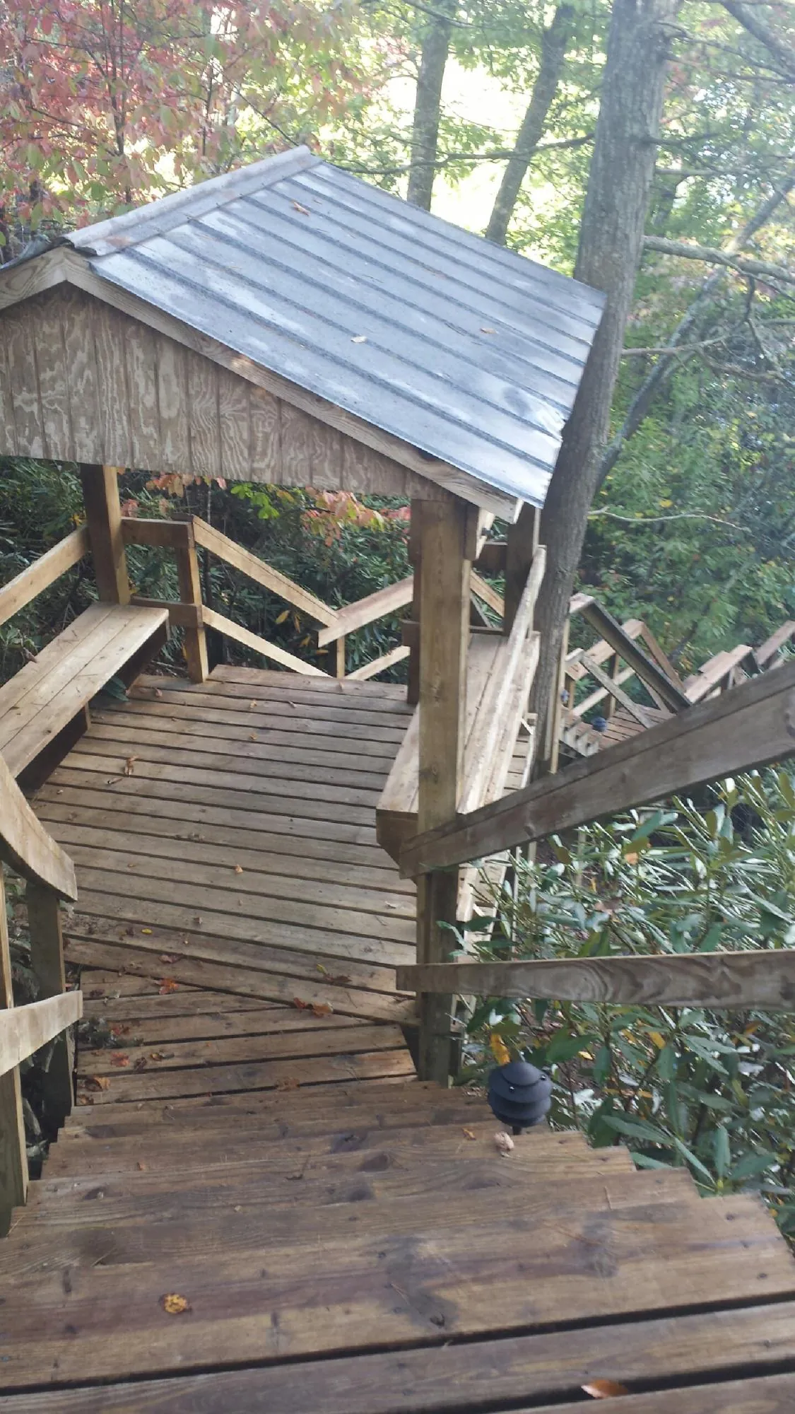Metal roofed shelter over wooden steps on a wooded walkway — Skylight Repair & Installation work by our crew in New Hartford
